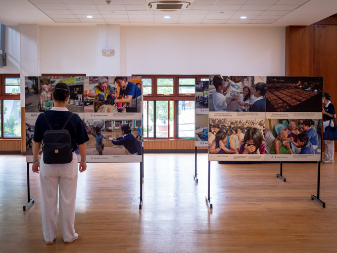 Tzu Chi volunteer looking over photos of previous Tzu Chi missions and relief operations.【Photo by Daniel Lazar】