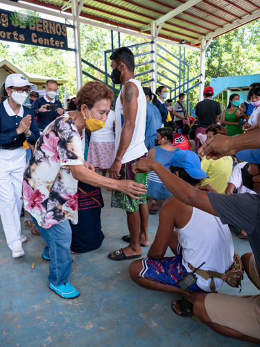 Tzu Chi member and local volunteer helping gather donations from recipients. 【Photo by Daniel Lazar】