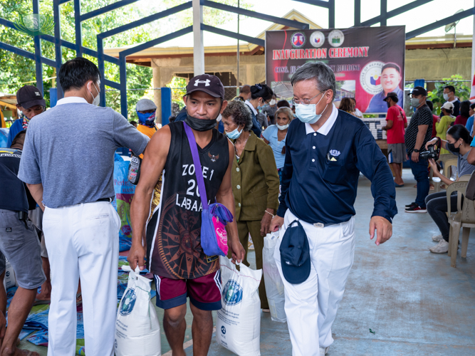 Tzu Chi member helping recipient with carrying their rice.【Photo by Daniel Lazar】
