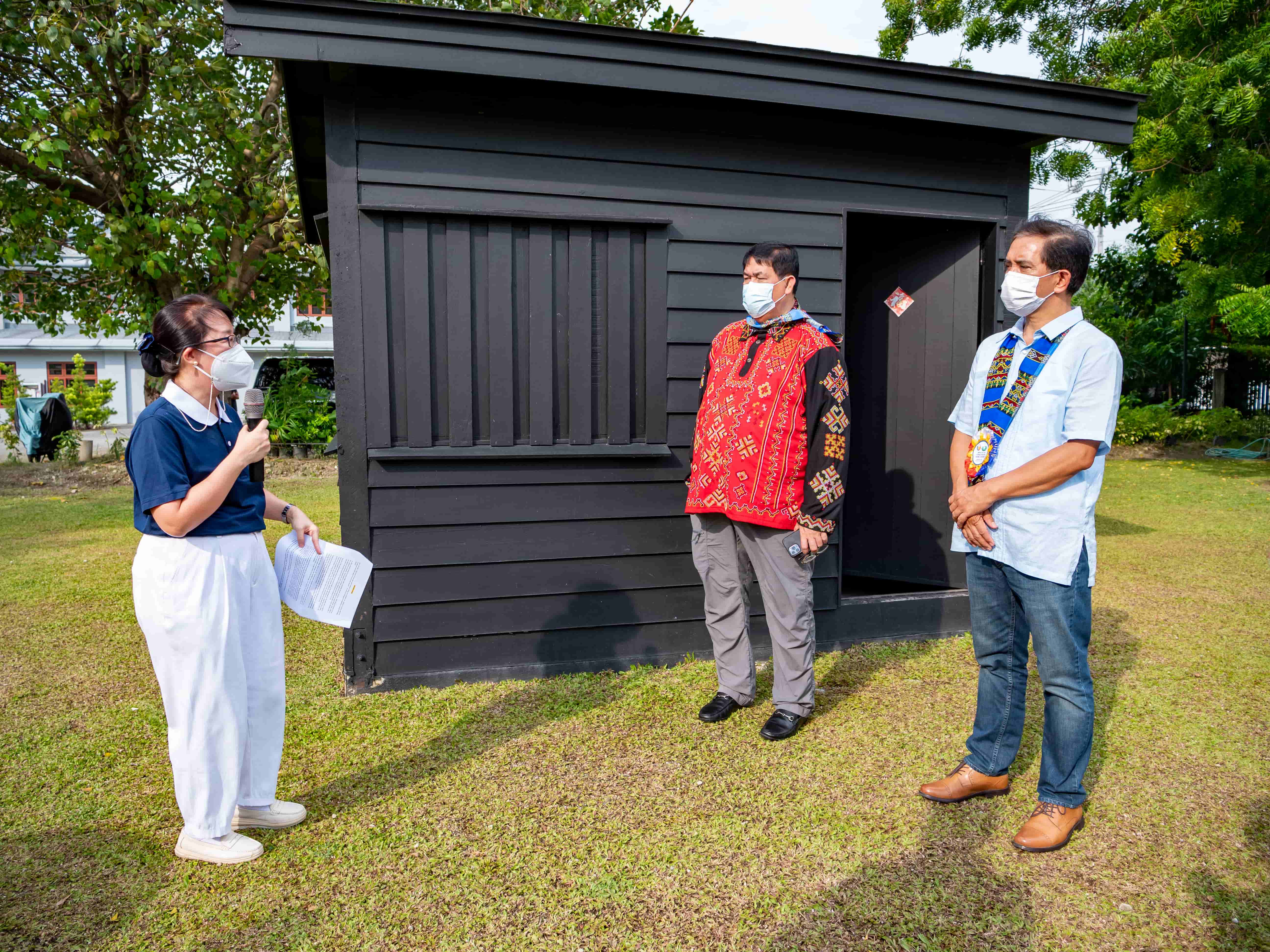Tzu Chi volunteers talking about the history of the wooden hut during the campus tour.【Photo by Daniel Lazar】