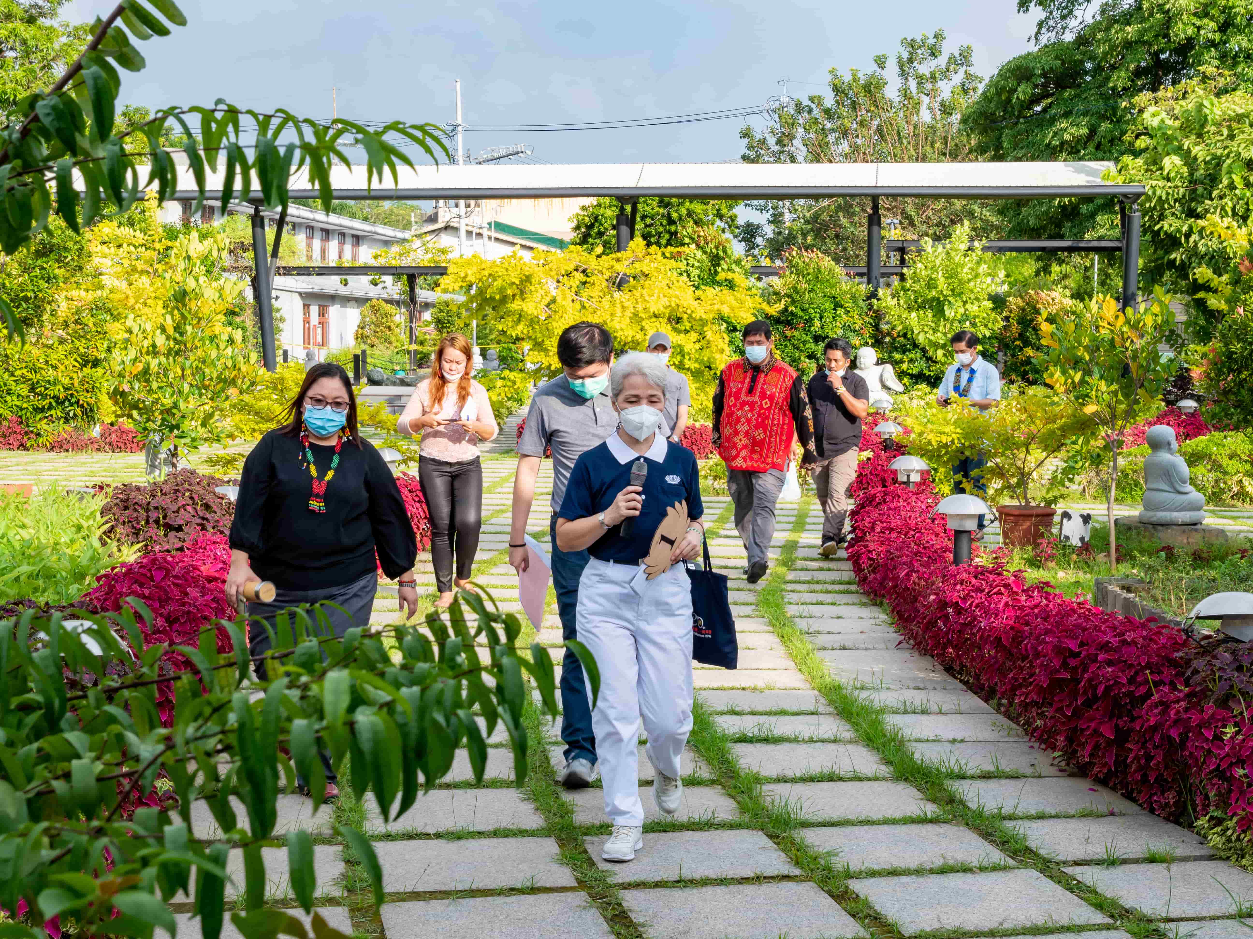 Tzu Chi Volunteer leading group on a tour of the campus towards the Coffee Shop.【Photo by Daniel Lazar】