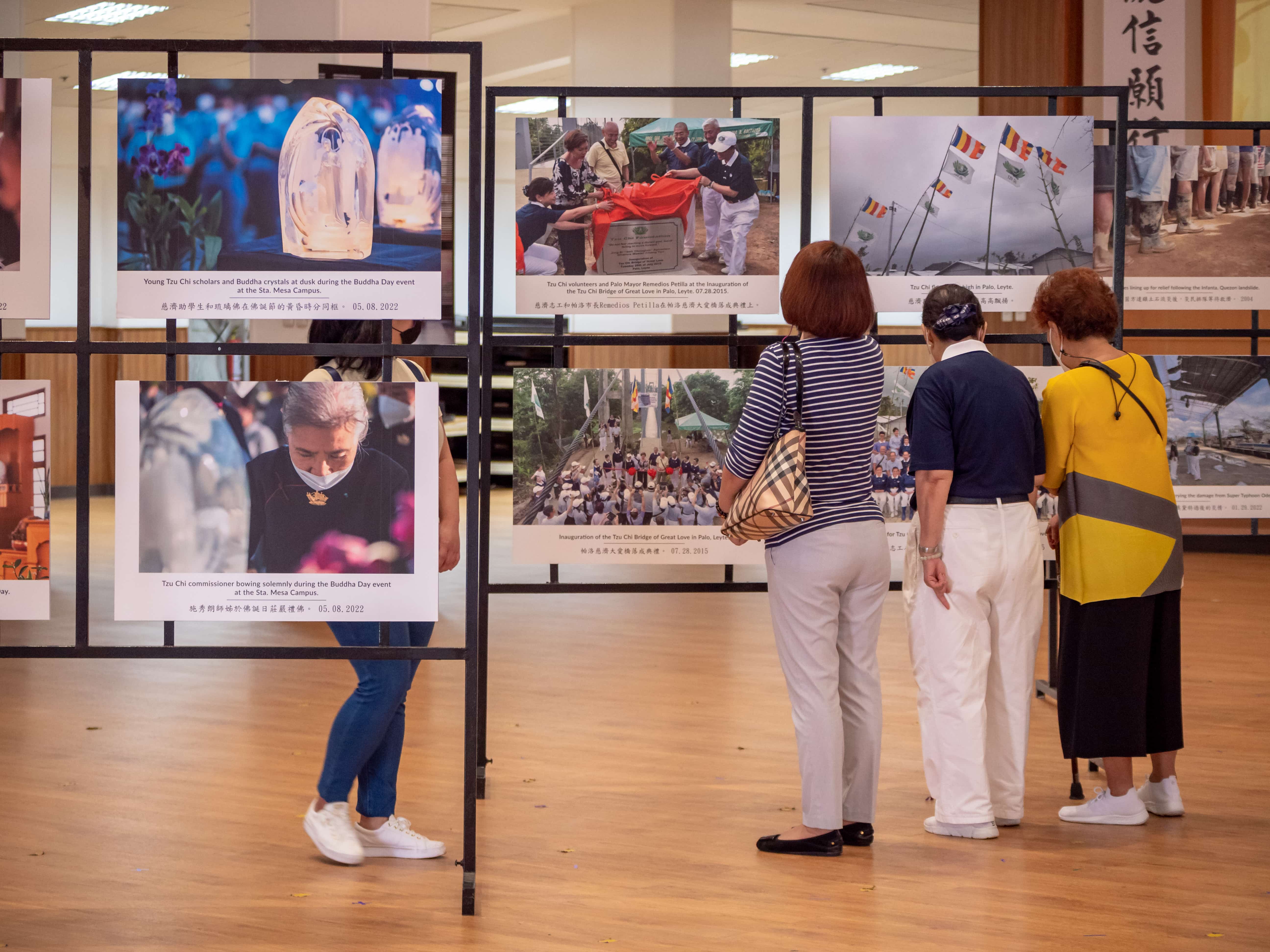 Tzu Chi volunteer perusing the photo collection with her family.【Photo by Daniel Lazar】