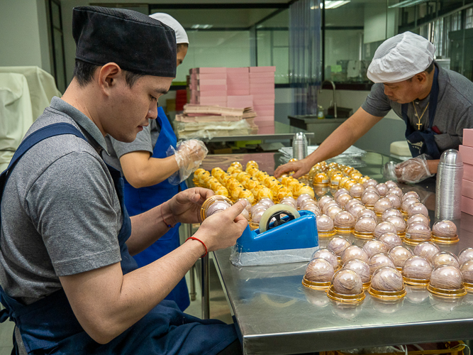 Tzu Chi’s team of bakers individually package their special Lotus and Taro puff mooncakes. 【Photo by Harold Alzaga】