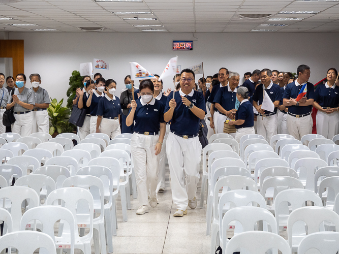 Waving flags, volunteers from Metro Manila, Bicol, Bohol Cebu, Davao, Palo, Pampanga, and Zamboanga make a lively entrance before the start of the planning session of the Tzu Chi 2023 Annual Meeting. 【Photo by Marella Saldonido】