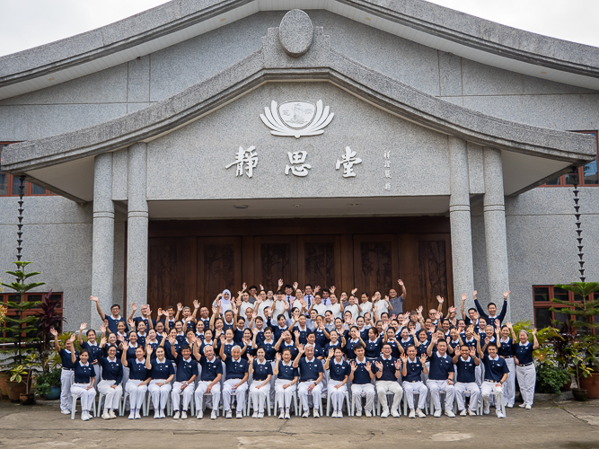 Volunteers wave to the camera in a souvenir photo taken outside BTCC’s Jing Si Hall. 【Photo by Marella Saldonido】