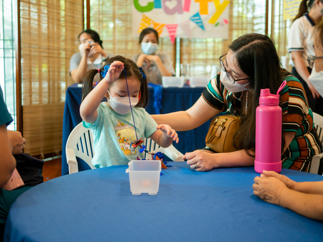 Parents and their kids engaging in craft-making activities【Photo by Daniel Lazar】