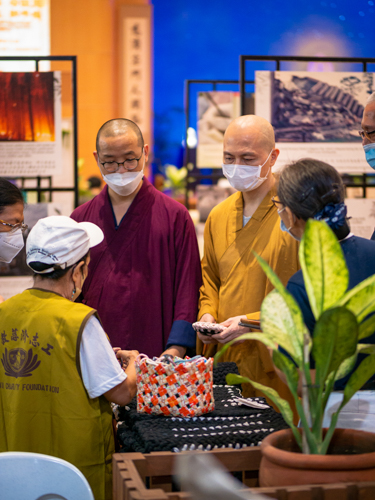 Rev. Pu Xue, and Rev Pu Yang discussing the upcycled products with Tzu Chi volunteers in Jing Si Hall.【Photo by Daniel Lazar】
