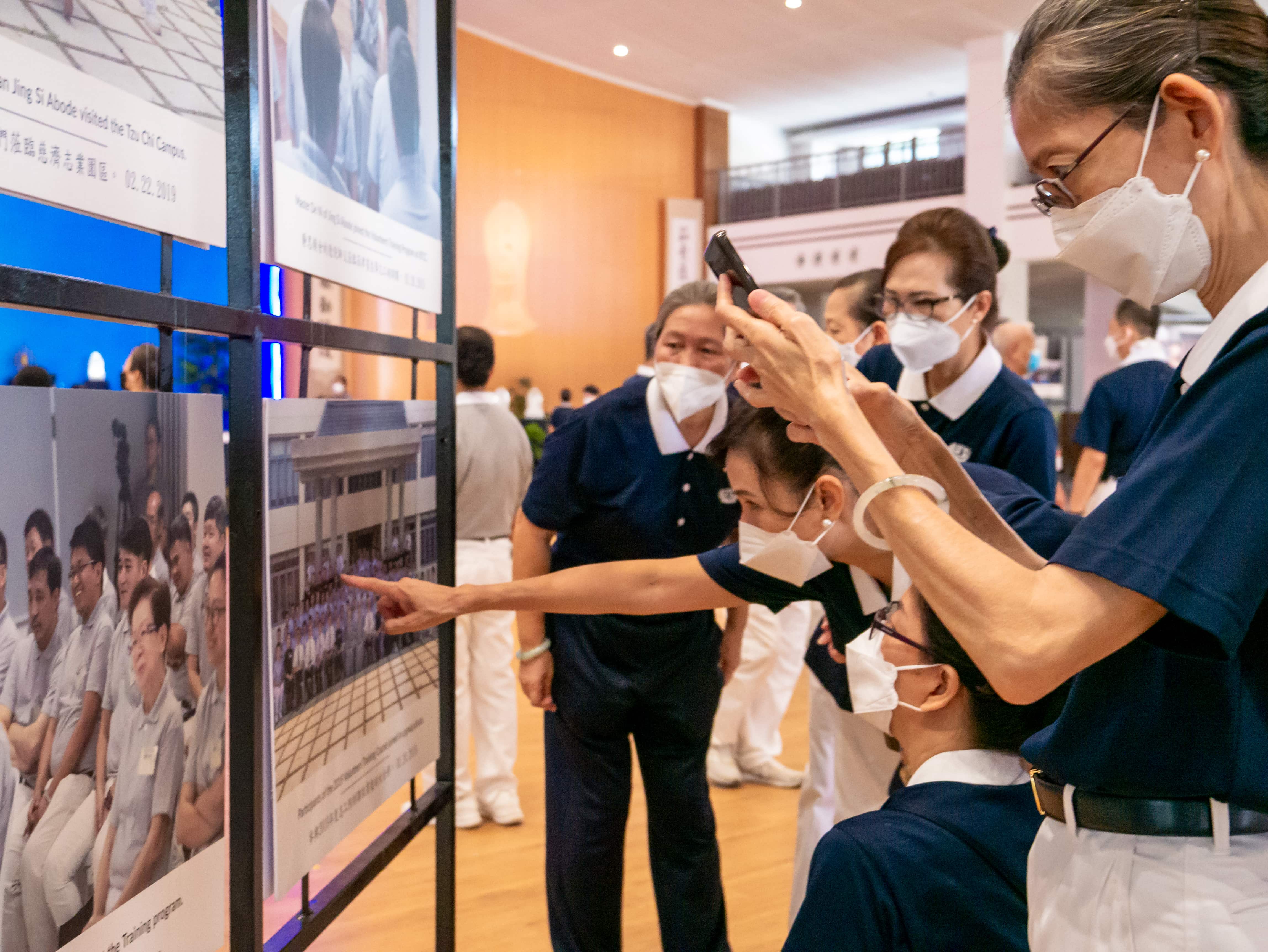 Volunteers trying to find themselves in a group photo.【Photo by Daniel Lazar】