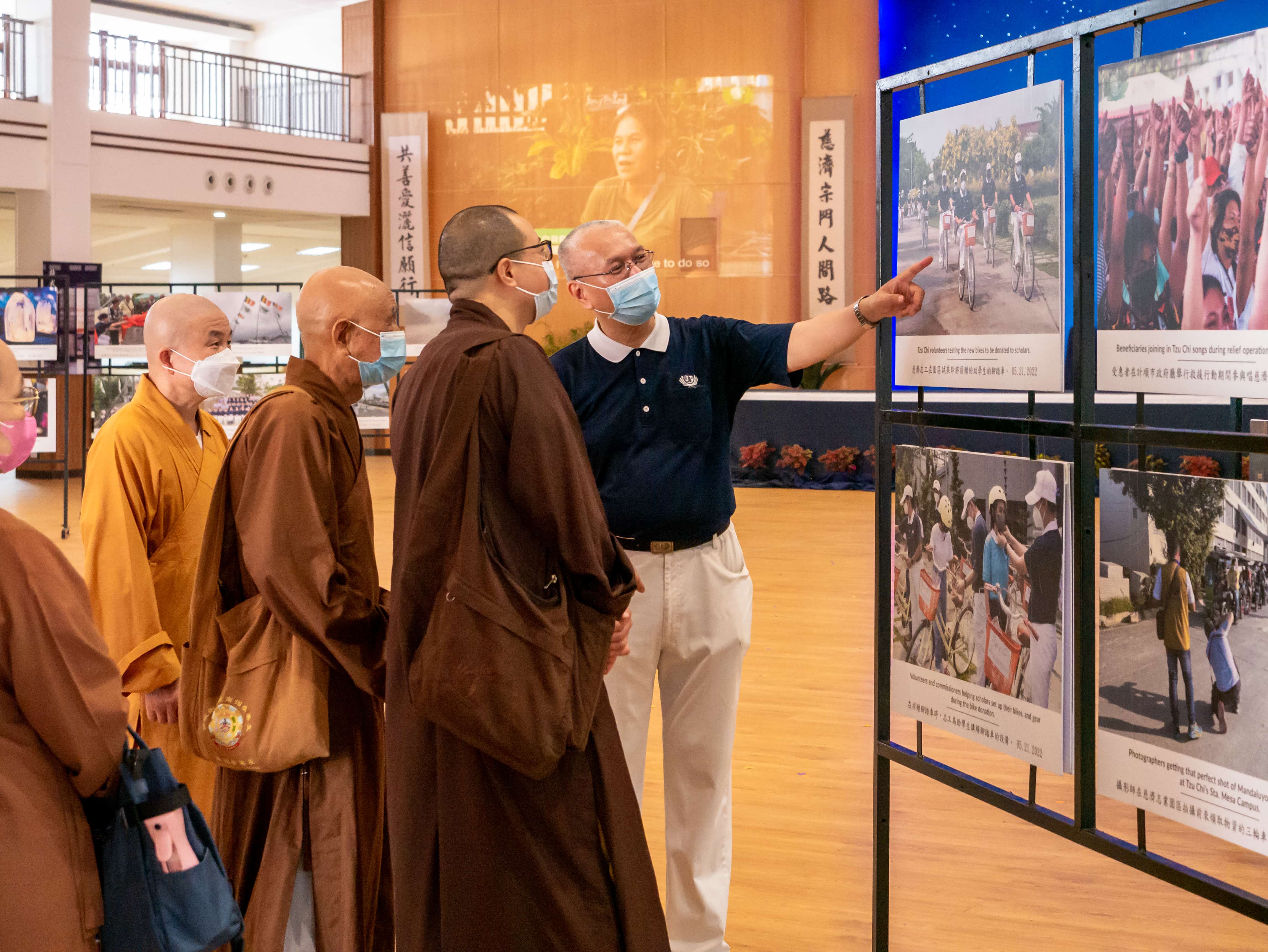 Dharma Masters visiting from Taiwan are given a tour of the gallery by Tzu Chi Commissioner Lino Sy.【Photo by Daniel Lazar】