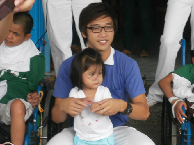 Leo Villanueva with one of the orphans of the Munting Tahanan ng Nazareth in Mabalacat, Pampanga