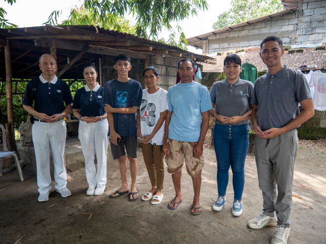 Ron Sirac Velasquez, his parents, and Tzu Chi volunteers pose for a photo during a home visit. 【Photo by Harold Alzaga】