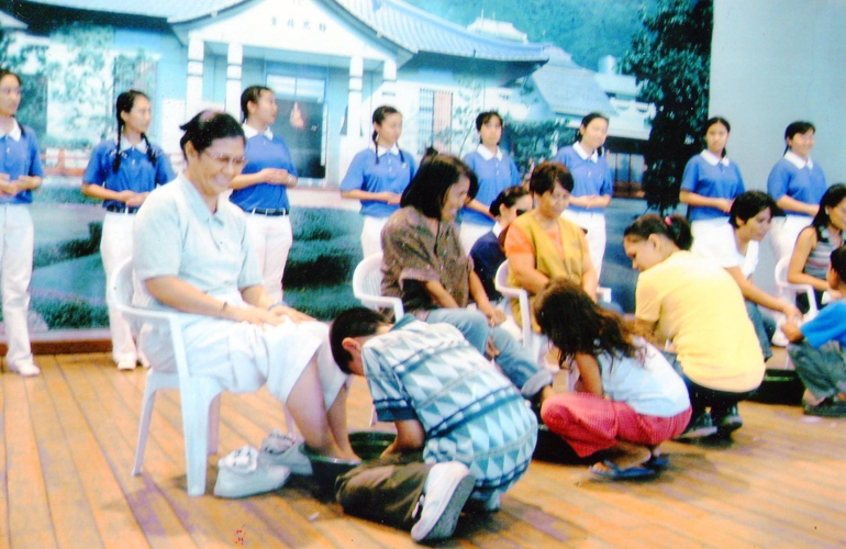 (Kneeling, first from left) Kinlon Fan washes his mom Terry’s feet during the 3-in-1 celebration of Buddha Day, Mother's Day, and Tzu Chi Day in 2007.