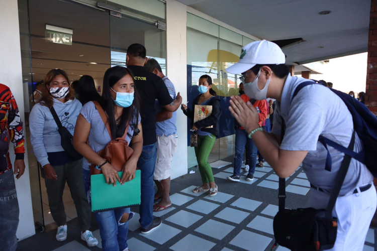 Kinlon Fan (right) bows before a beneficiary in a cash assistance program for victims of Super Typhoon Odette (Rai) in Cebu in January 2022.