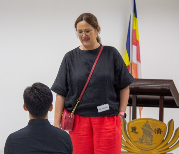 Maridol Siapuatco, head of Metrobank’s program management division (standing) chats with Tzu Chi scholar Jefferson Aguilar during the break. She recommends that he and others identify themselves as Tzu Chi scholars “to promote the awareness of Tzu Chi, especially the values formation training it gives its scholars and the holistic way it helps scholars and their families.”