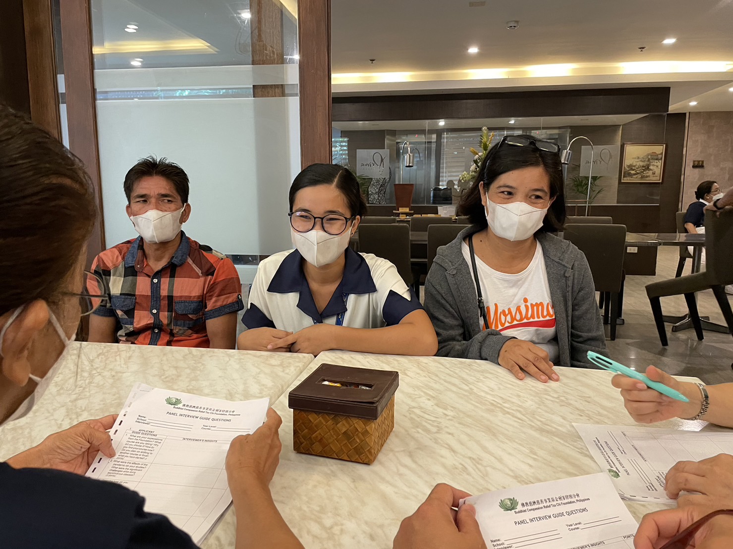 Flanked by her father Jose (left) and mother Annie (right), Jazel Basto (center) meets with Tzu Chi Foundation volunteers during an interview with scholar candidates and their parents.【Photo by Jeaneal Dando】