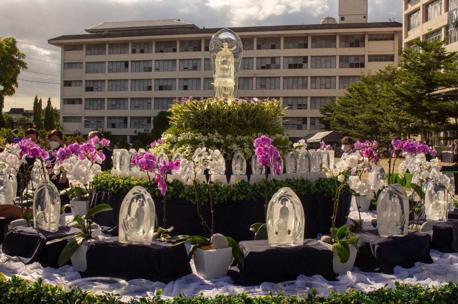 Flowers and greens surround crystal Buddhas of different sizes. 【Photo by Mavi Saldonido】