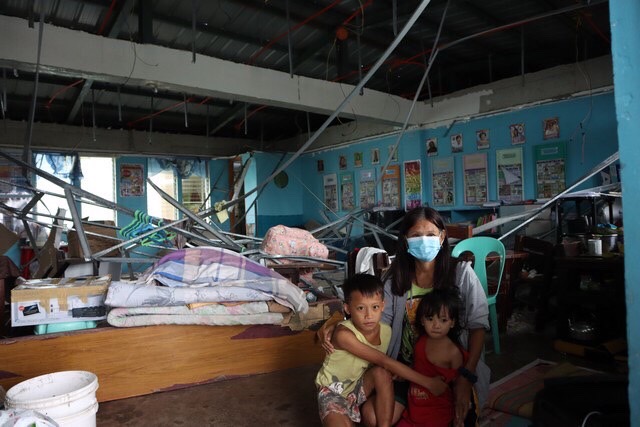 Marietta Sembrano and her grandkids take cover in the second floor of Ibo Elementary School. The ceiling frame of this temporary shelter collapsed during the onslaught of Odette. Luckily, no one was hurt. 