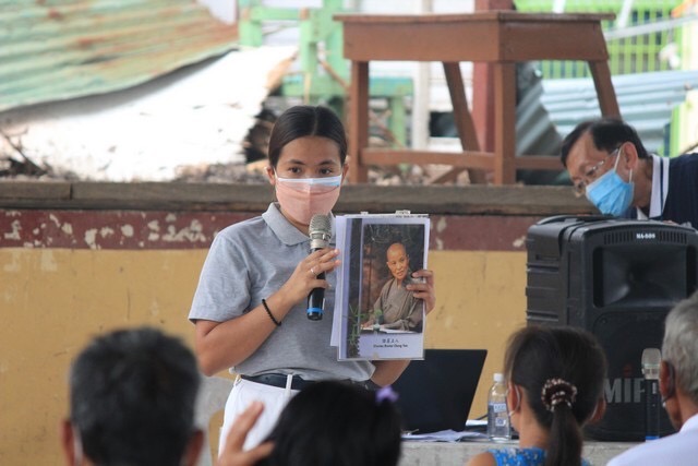 A volunteer introduces beneficiaries to the founder of the Tzu Chi Foundation, Dharma Master Cheng Yen.