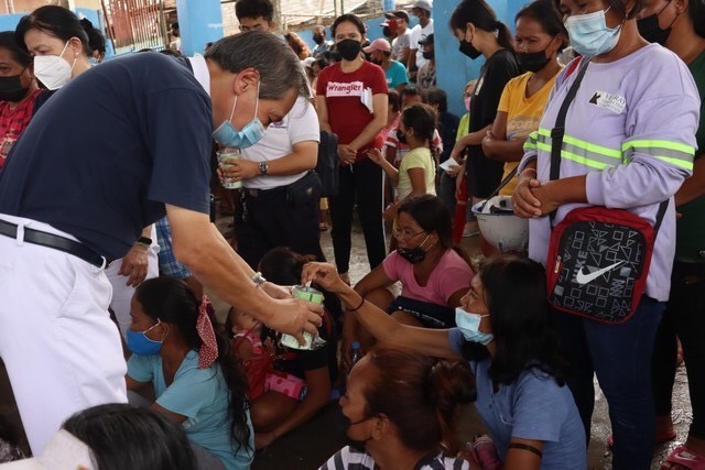 Giving is a privilege of the sincere: A Tzu Chi beneficiary practices what Dharma Master Cheng Yen preaches and puts money in a volunteer’s coin bank. 