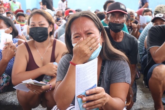 A beneficiary gets emotional upon hearing that she and others would receive cash assistance from Tzu Chi Foundation. 