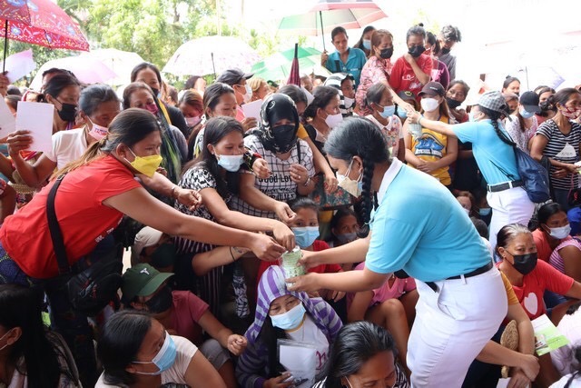 In Sibonga, rice relief beneficiaries drop their last centavos in a Tzu Chi youth volunteer’s coin bank in a show of support for others who are also in need. 