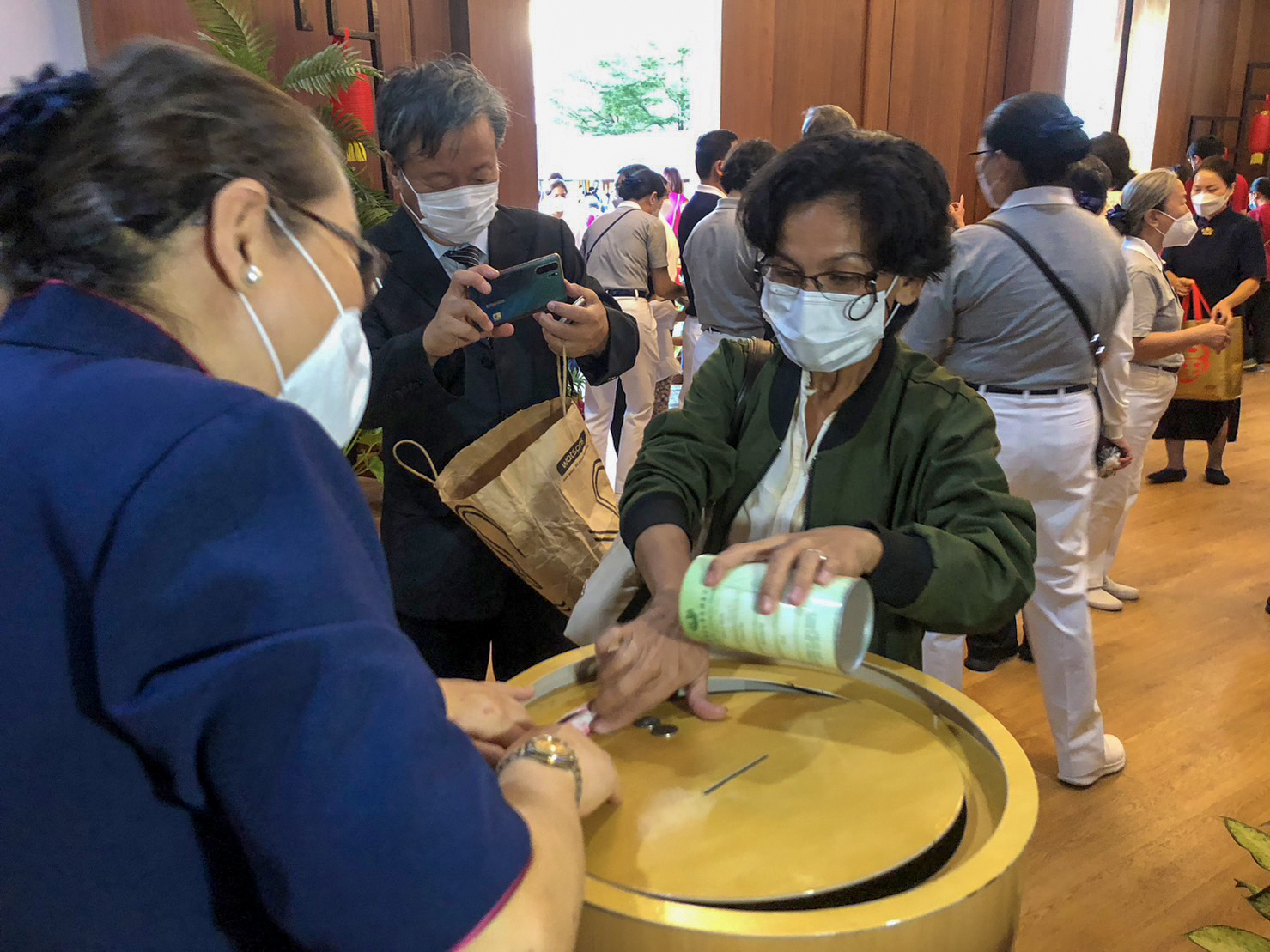 Labelyn Rosales transfers her donation to Tzu Chi’s big coin banks. 【Photo by Ben Baquilod】