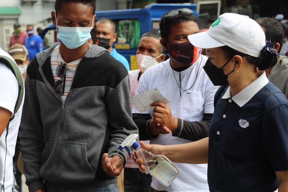 Safety protocols, like spraying people’s hands with alcohol, were observed during the release of cash aid.
