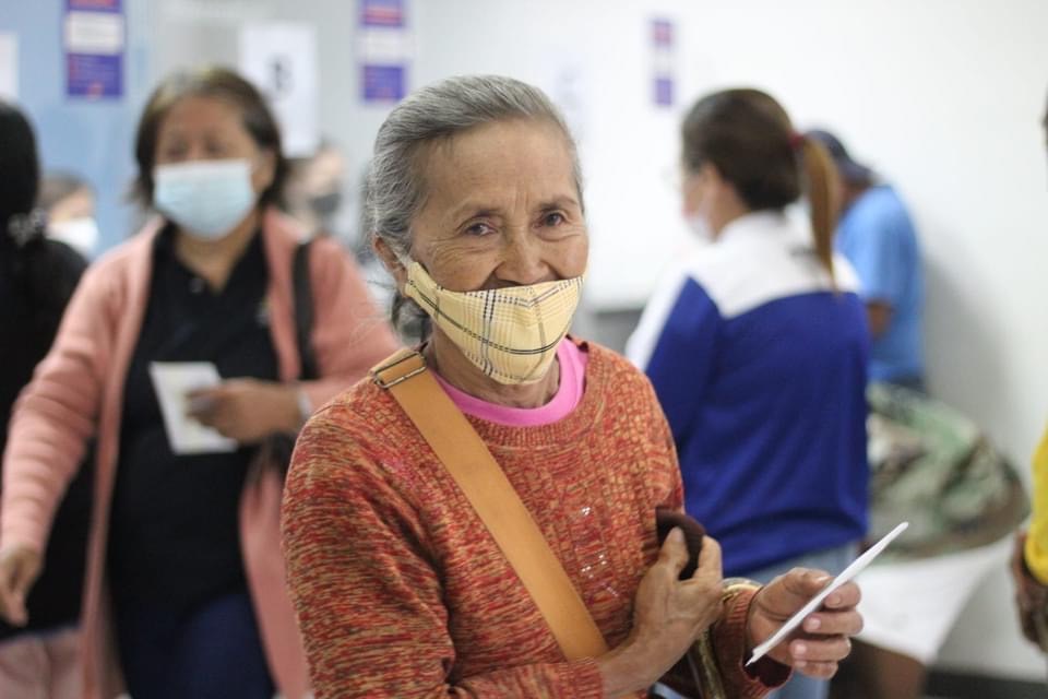 A woman leaves the teller with her envelope of financial assistance.