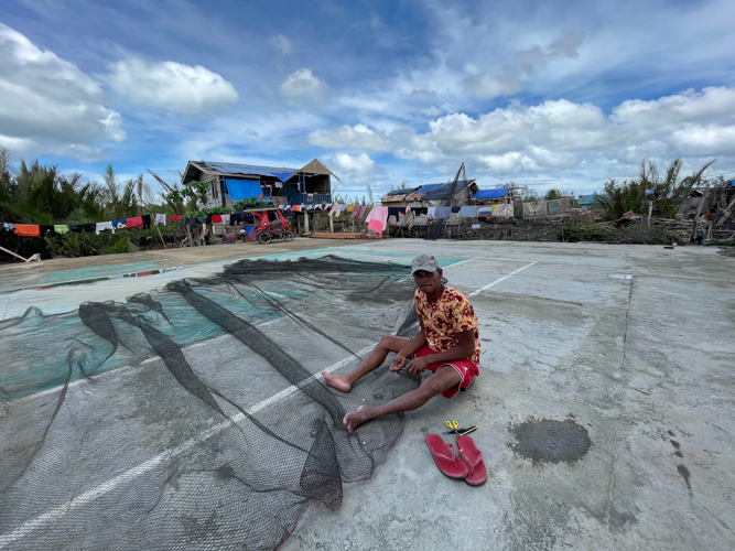 A fisherman mends his net in Barangay Sto. Nino. 【Photo by Marella Saldonido】