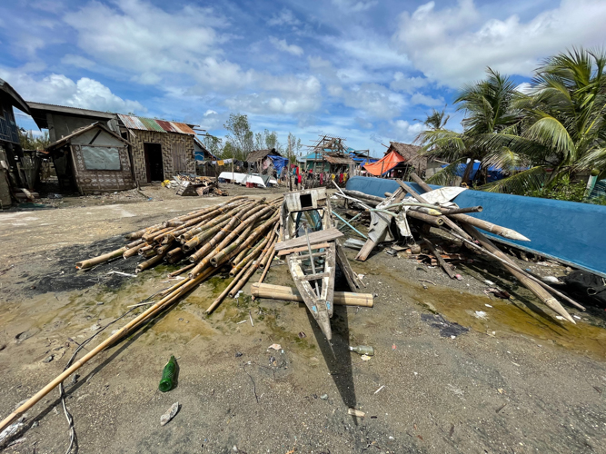 Destroyed by Odette, a fishing boat lies next to discarded debris. 【Photo by Marella Saldonido】