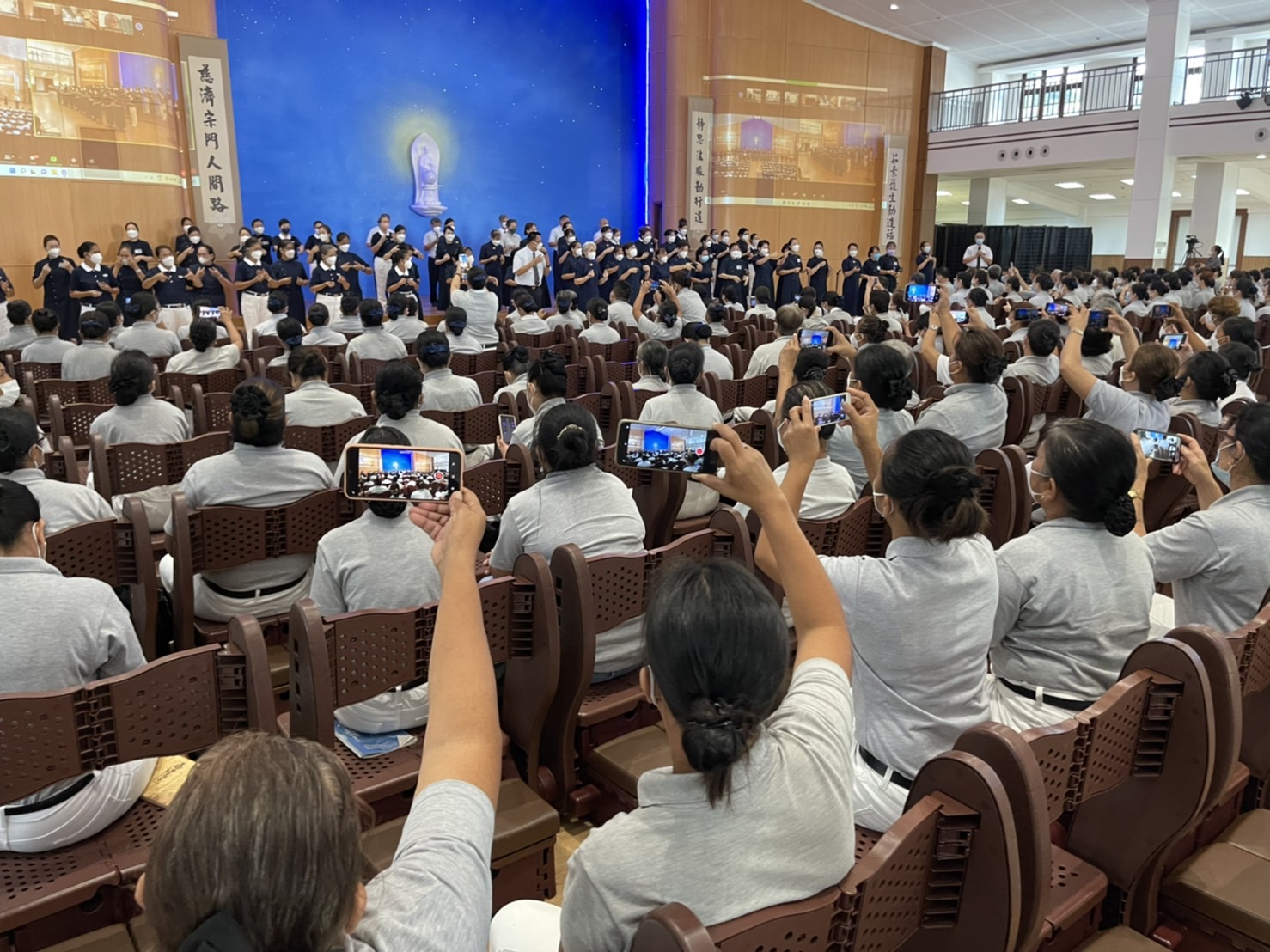 Volunteers take a video of Group Leaders and Commissioners performing the sign language to “One Family.”【Photo by Judy Lao】