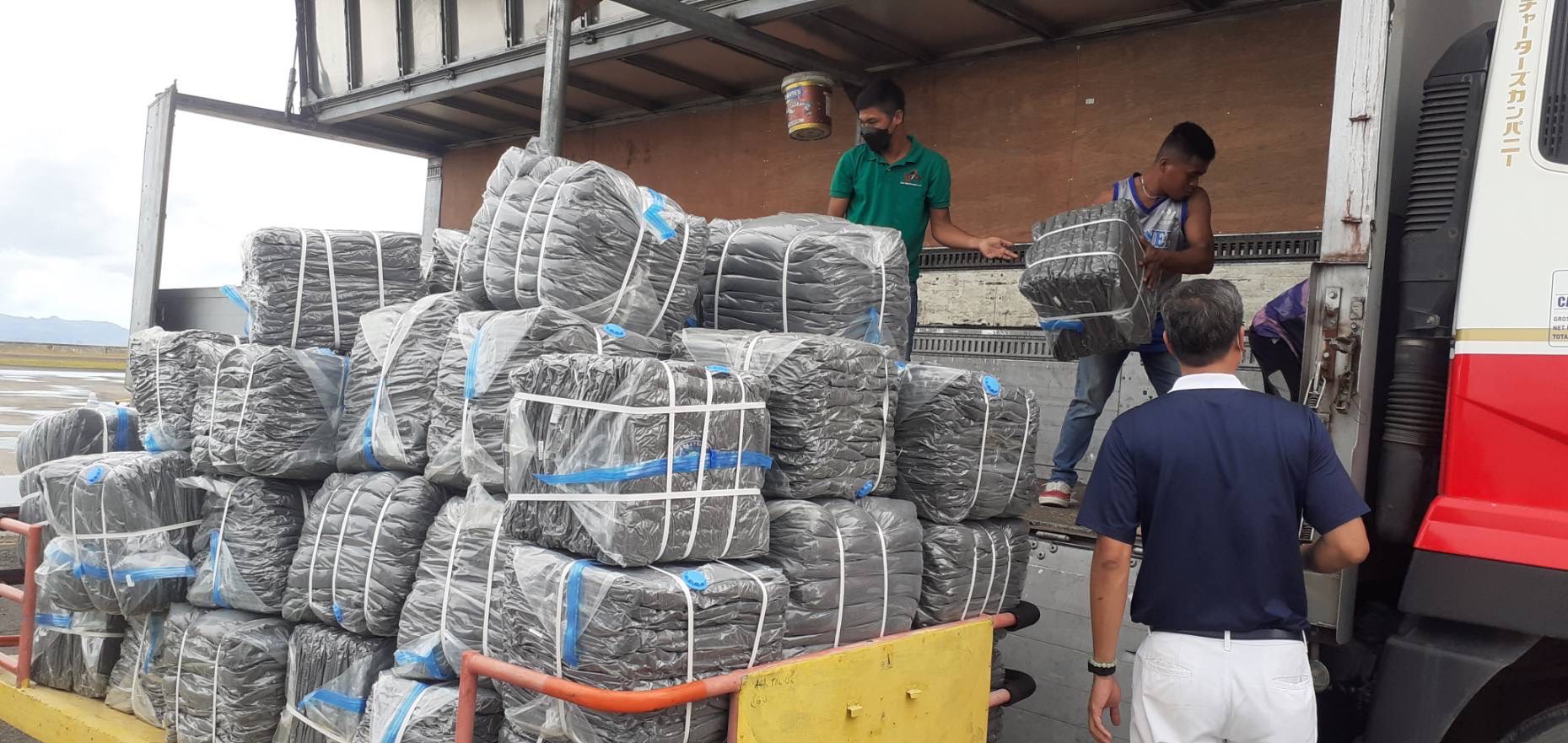 Volunteers in Tacloban load the donated blankets into a truck for distribution.