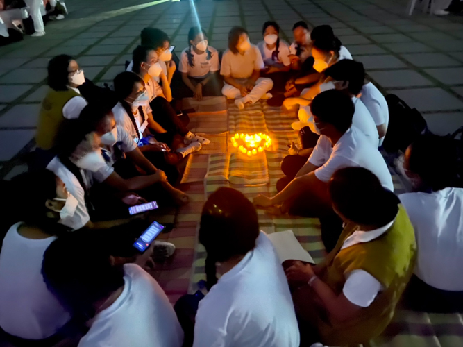 Scholars huddle together outside Harmony Hall for an intimate sharing session.【Photo by Harold Alzaga】