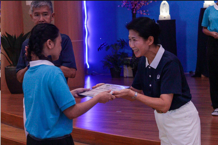 Tzu Chi Philippines Deputy CEO Woon Ng (right) presents a certificate to a new Tzu Chi scholar. 【Photo by Kinlon Fan】
