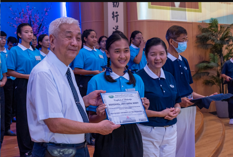 Flanked by Tzu Chi Philippines CEO Henry Yuñez (left) and Tzu Chi Education Committee Head Rosa So (right) Jho Anna Khey Mendoza of Polytechnic University of the Philippines was one of 69 new scholars to receive a certificate in an awarding ceremony held on October 8. 【Photo by Jeaneal Dando】