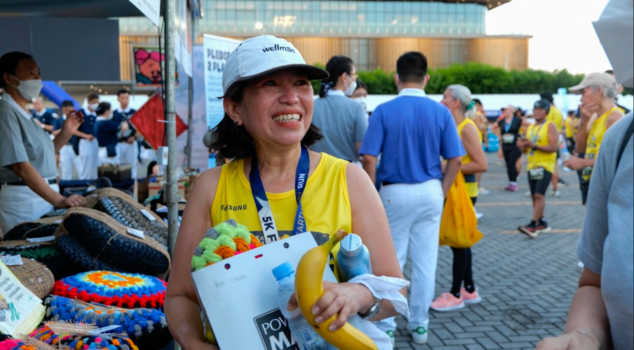 After finishing 5K, Mae Juliet de la Cruz purchased Tzu Chi's stool cover made of excess sport sock material. The Amang Rodriguez Memorial Medical Center anesthesiologist limits her use of plastics, brings her own water bottle, mug, and utensils to work, and keeps a lake near her farm in Boso Boso, Antipolo clean. 【Photo by Jeaneal Dando】