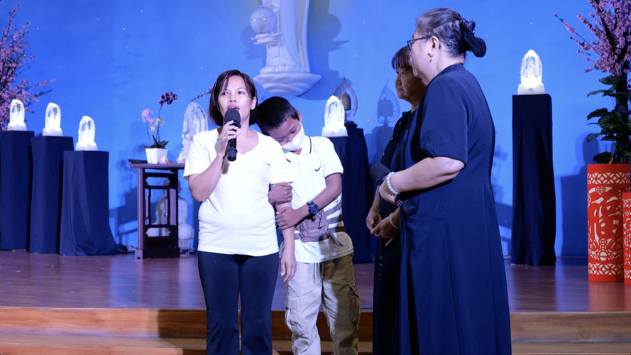 With volunteers Shirley Chua and Ting Ting Pua (first and second from right) looking on, Lenlen Galban speaks for her son Prince, who clings shyly to her side. Upon sustaining a fracture from a fall, Prince was later diagnosed with Pott disease or tuberculosis of the spine. Thanks to Tzu Chi’s assistance, the boy who felt excruciating pain with every movement can now play, attend school, and make TikTok videos.