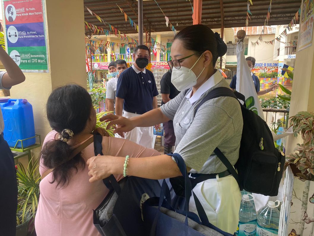 Zamboanga volunteer Shan Ling Wang hands relief goods over to an evacuee from Tubunan Elementary School.