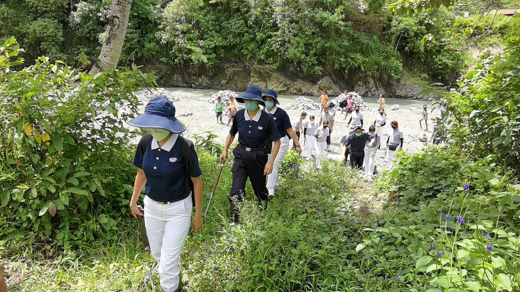 Volunteers cross a river on their way to the banana farming site in Talaingod, Davao del Norte.