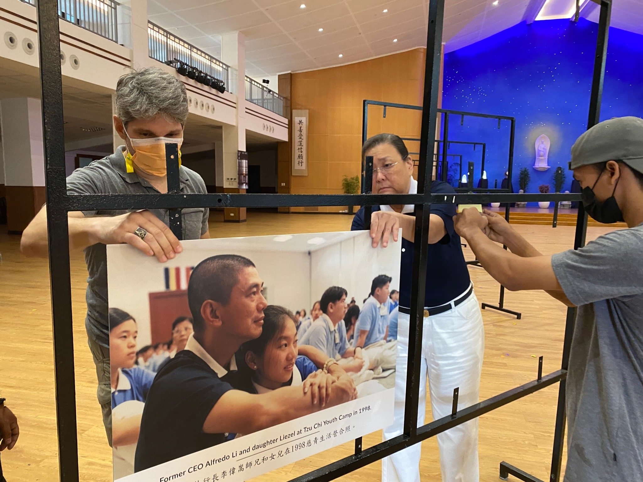 Tzu Chi’s Communications Department install exhibit photos on stands. 【Photo by Harold Alzaga】