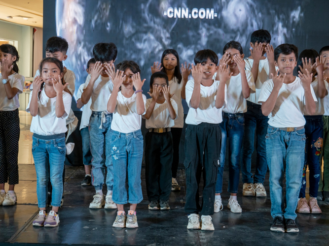 Tzu Chi scholars and children from Palo Great Love Village perform a song with sign language. 【Photo by Matt Serrano】