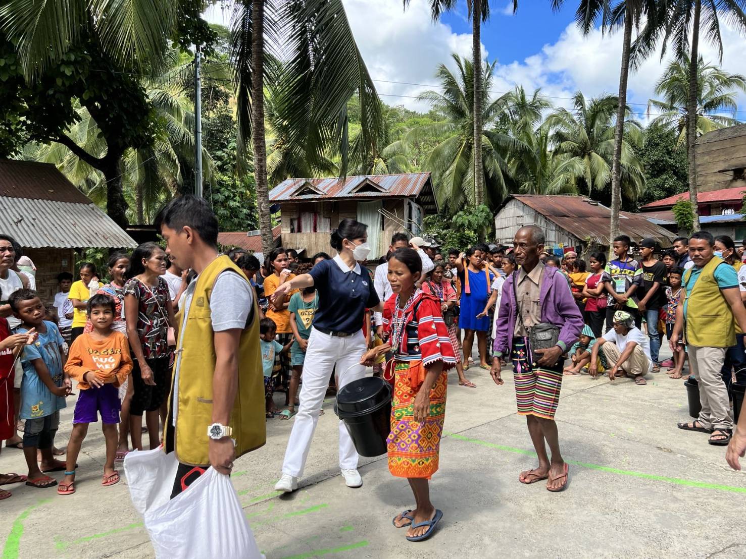 Tzu Chi Davao volunteer Ang Mei Yuan guides beneficiaries during relief distribution.