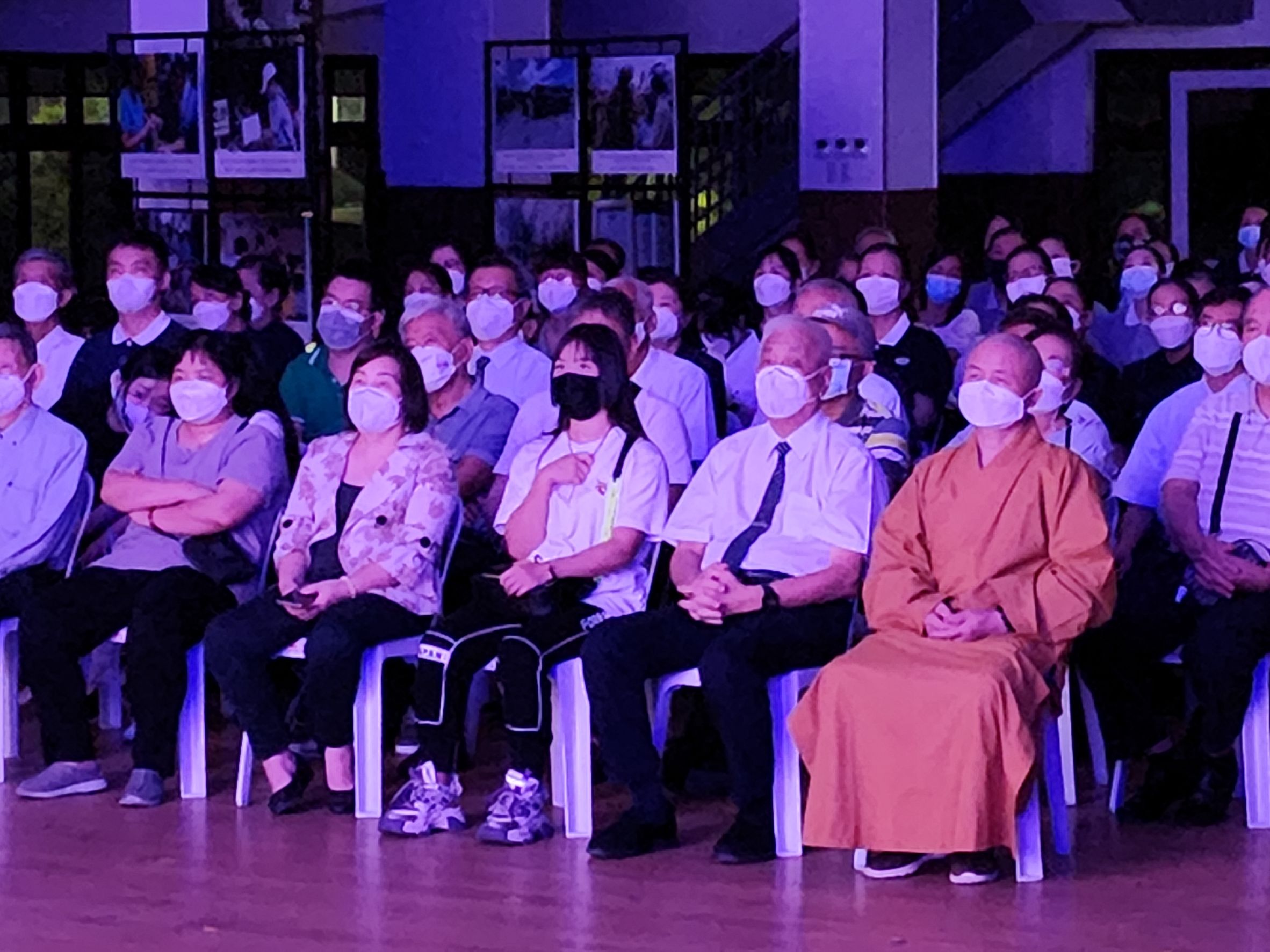 Buddhist monk sits beside Tzu Chi Philippines CEO Henry Yuñez during the live viewing of the Lotus Sutra Musical Adaptation attended by Tzu Chi volunteers and guests.