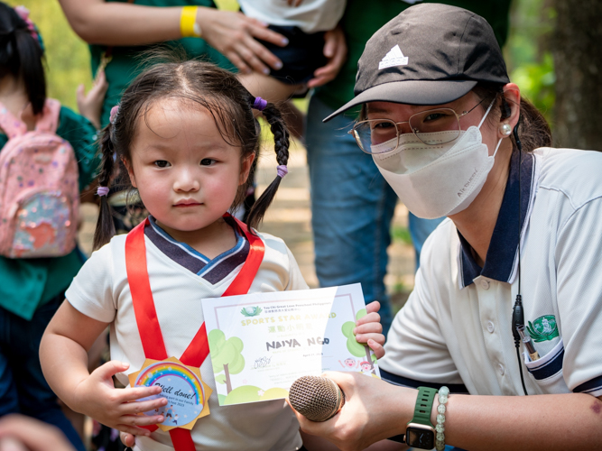 Preschool student Naiya Ngo receives an award from Preschool Directress Jane Sy. 【Photo by Daniel Lazar】
