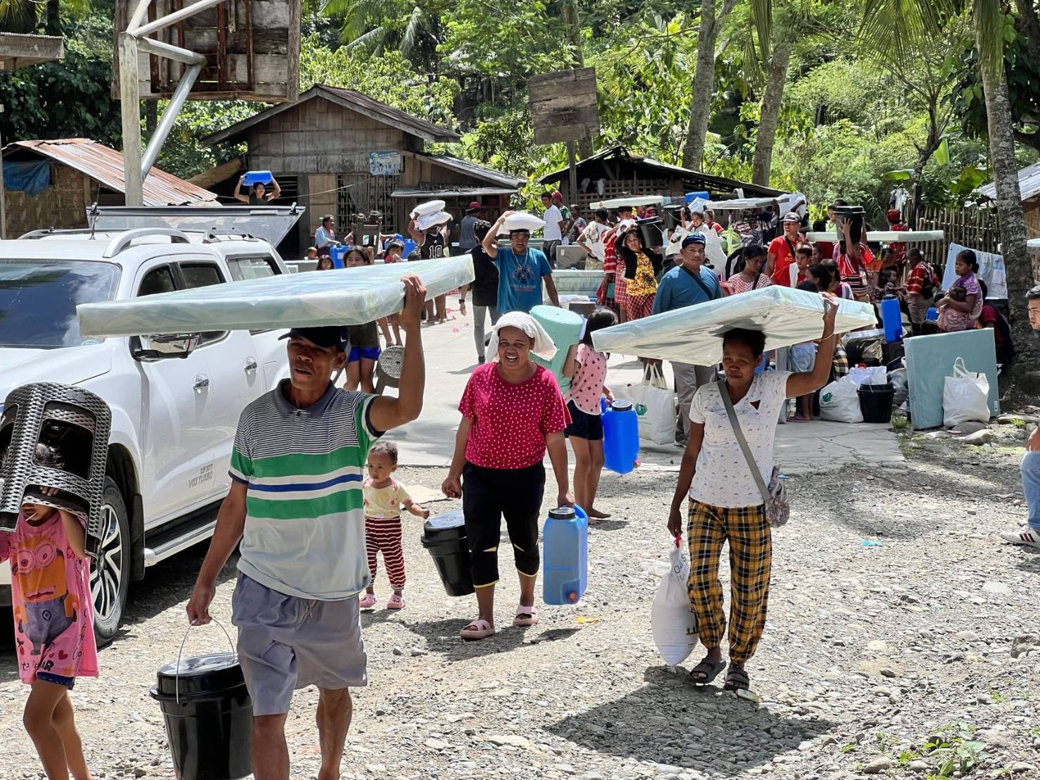 Beneficiaries happily carry home their relief goods.