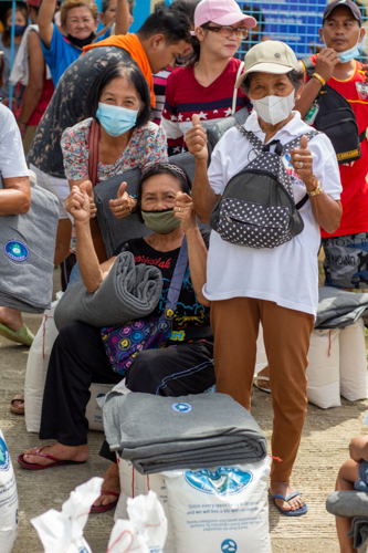 Beneficiaries say ‘thank you’ in Mandarin sign language. 【Photo by Matt Serrano】