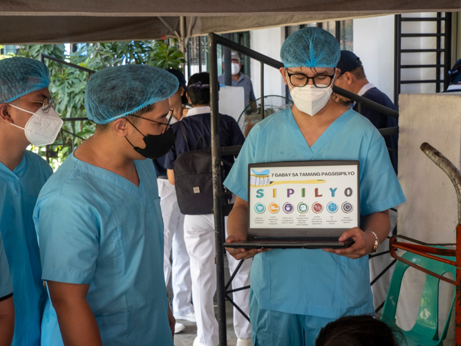 While patients wait for their turn at the dental area, volunteer doctors present a short lecture on oral health.