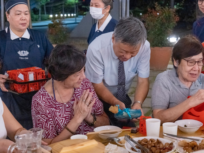 Volunteers present guests with a bag of fresh round fruits and tokens of good luck, as well as a special gift from Master Cheng Yen: an ampao with a commemorative coin and three grains of rice representing wisdom, discipline, and determination. 【Photo by Matt Serrano】