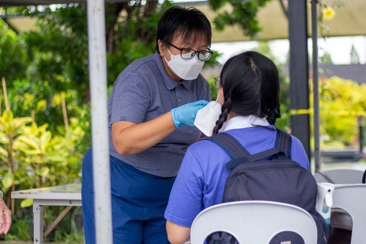 Tina Pasion of Tzu Chi’s Charity Department volunteers in the swabbing of camp participants. 【Photo by Matt Serrano】