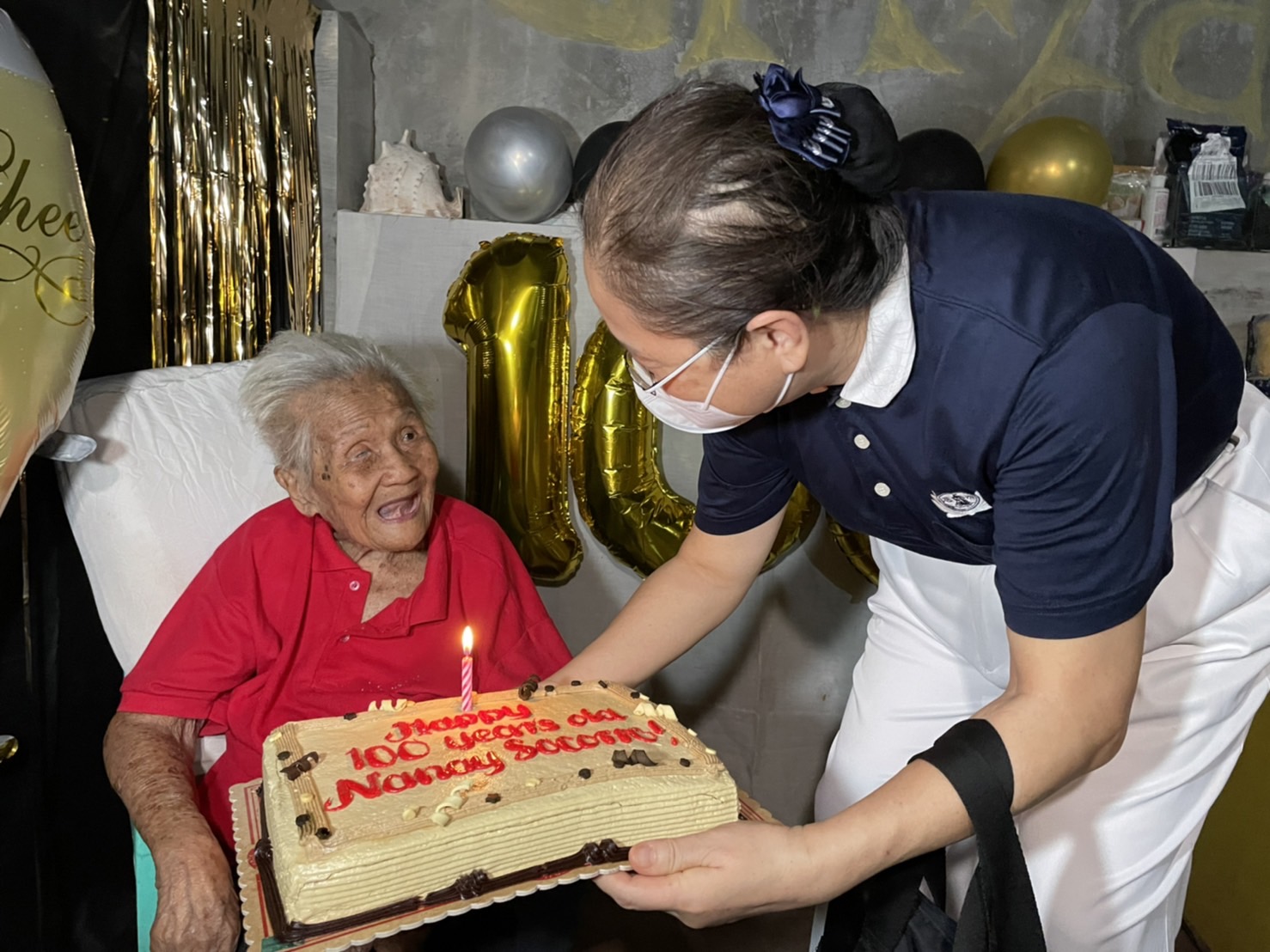 Tzu Chi volunteers visited long-time beneficiary Socorro Bello to celebrate her 100th birthday. They surprised the centenarian with a bag of groceries, rice, cash allowance, and birthday cake. 【Photo by Jeaneal Dando】